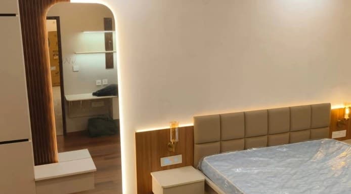 Bedroom with tufted headboard, timber wall and warm wall lights