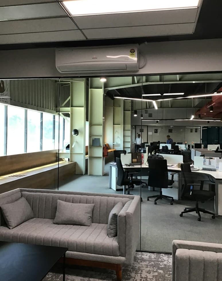 Open-plan workplace with lounge seating and glass partitions