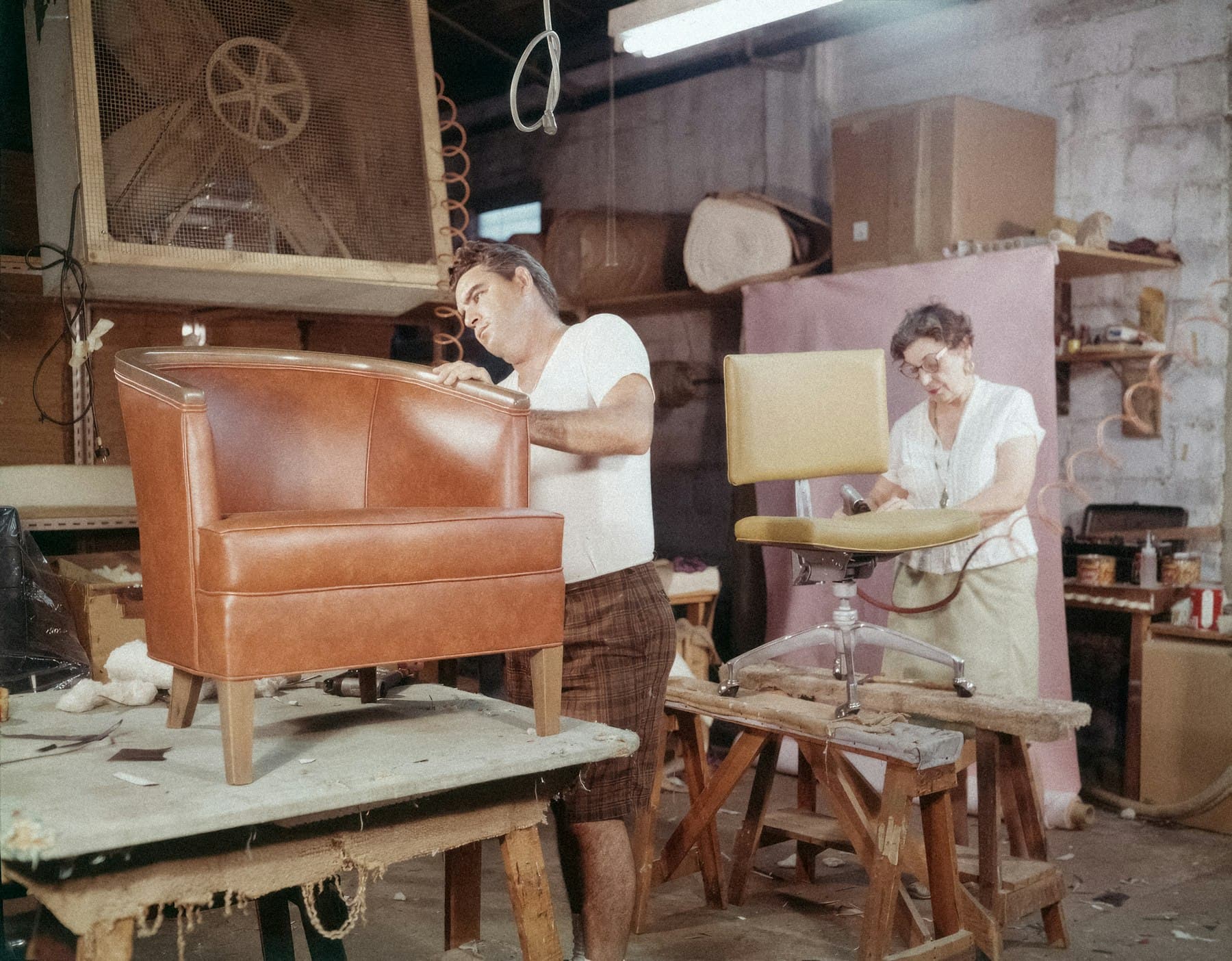 Upholsterers crafting a leather armchair in the workshop