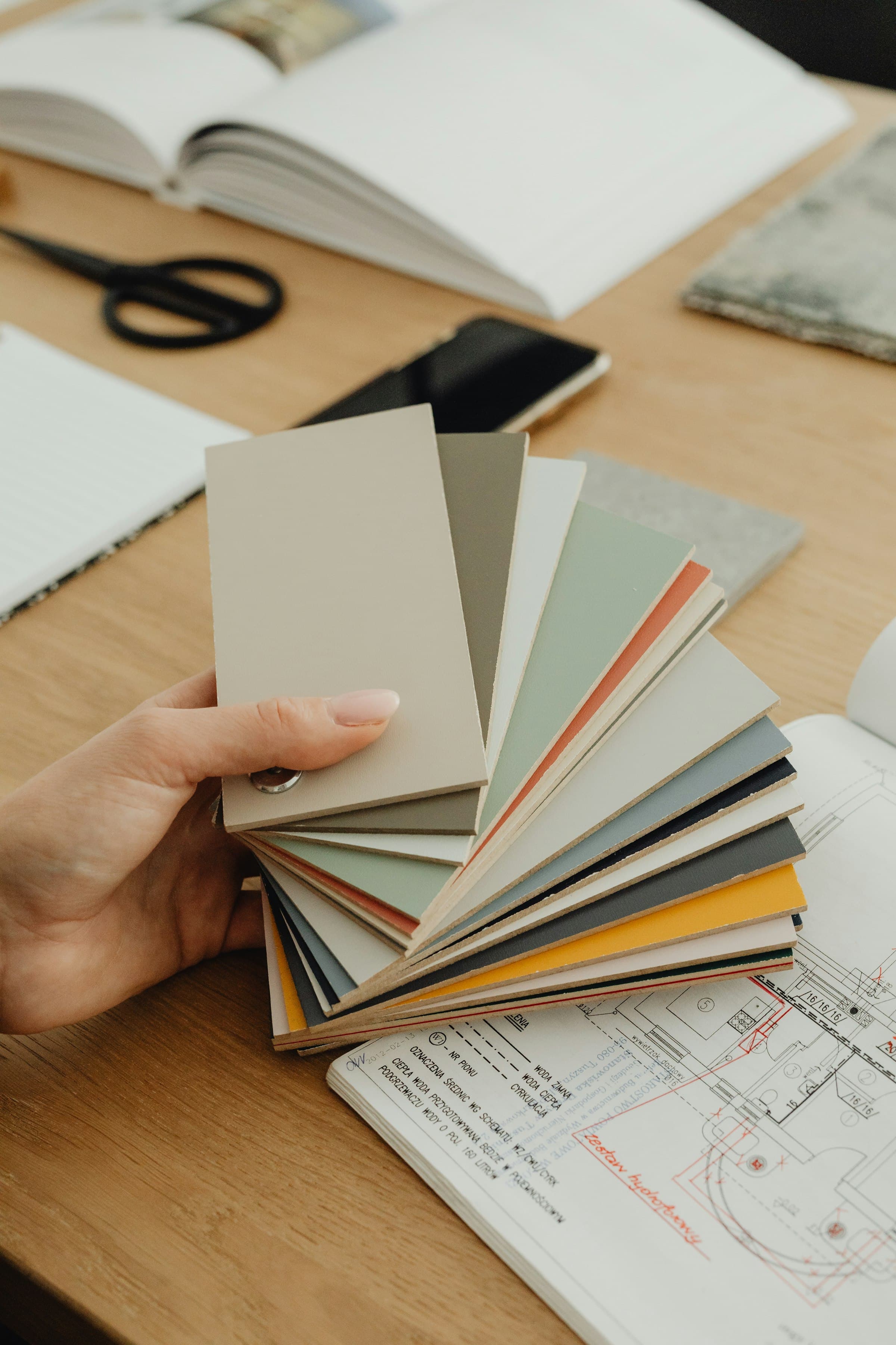 Hand holding colour swatches over drawings
